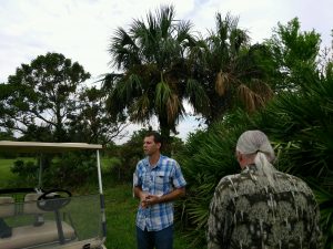 Dr. Brian Bahder on UF IFAS FLREC campus with diseased Sabal palms behind him.